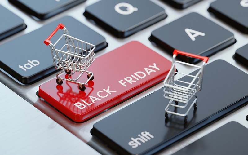 Modern computer keyboard with a shopping carts and a red Black Friday button.  Horizontal composition with selective focus and copy space. Great use for shopping and Cyber Monday related concepts.